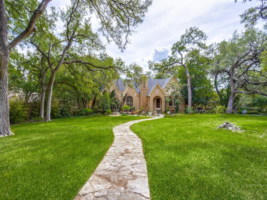 Tudor house featuring a front lawn, stone siding,