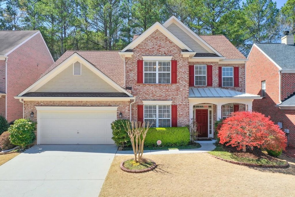 View of front facade featuring brick siding, driveway, a garage, and a shingled roof