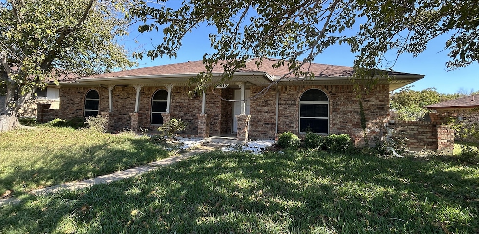 Ranch-style house featuring a front lawn, covered porch, and brick siding