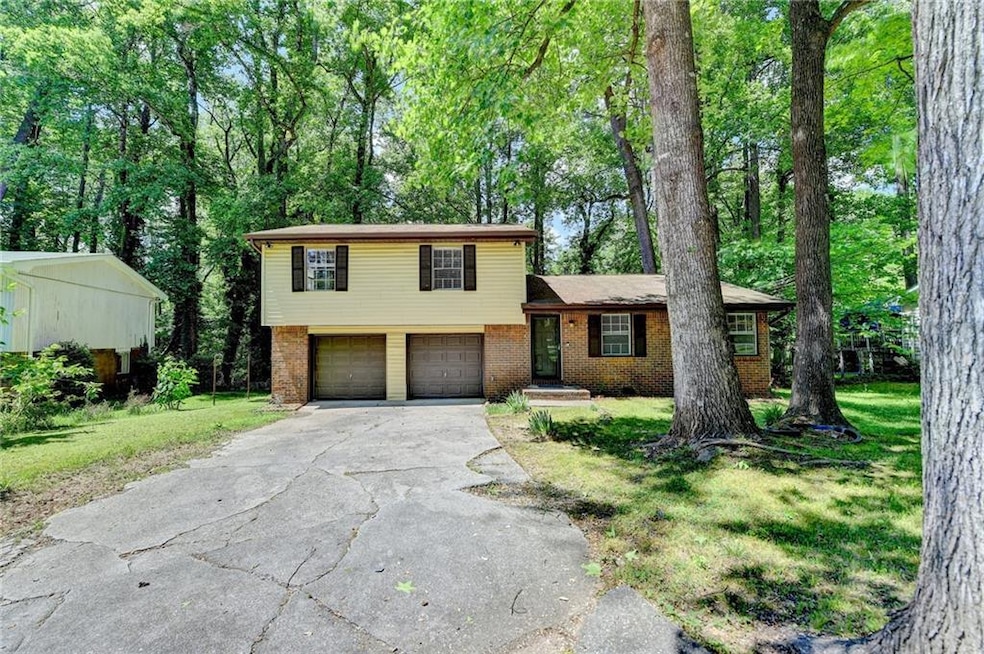 Split level home featuring driveway, brick siding,