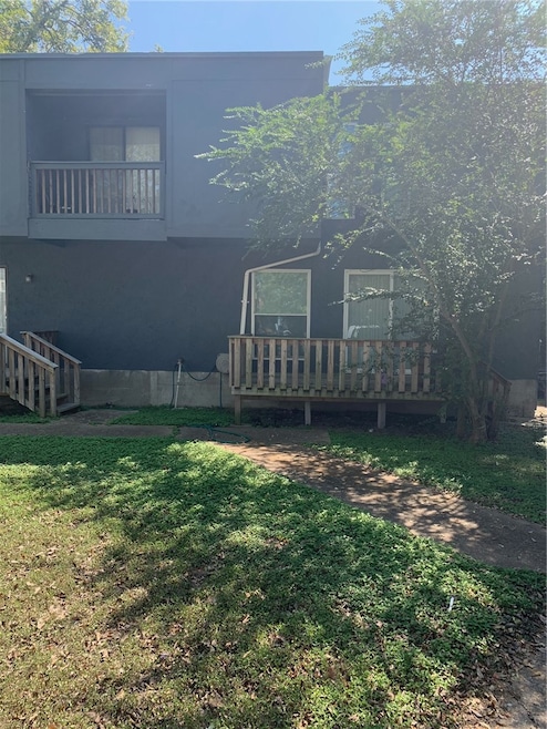 Back of house with a yard and a balcony