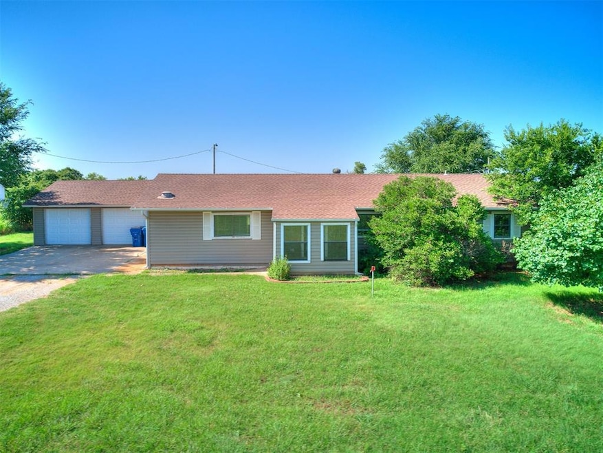 Single story home featuring driveway, a front lawn, a shingled roof, and a garage