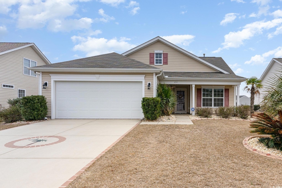 View of front of house featuring driveway, a shing