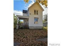 Back of property with covered porch and stucco siding