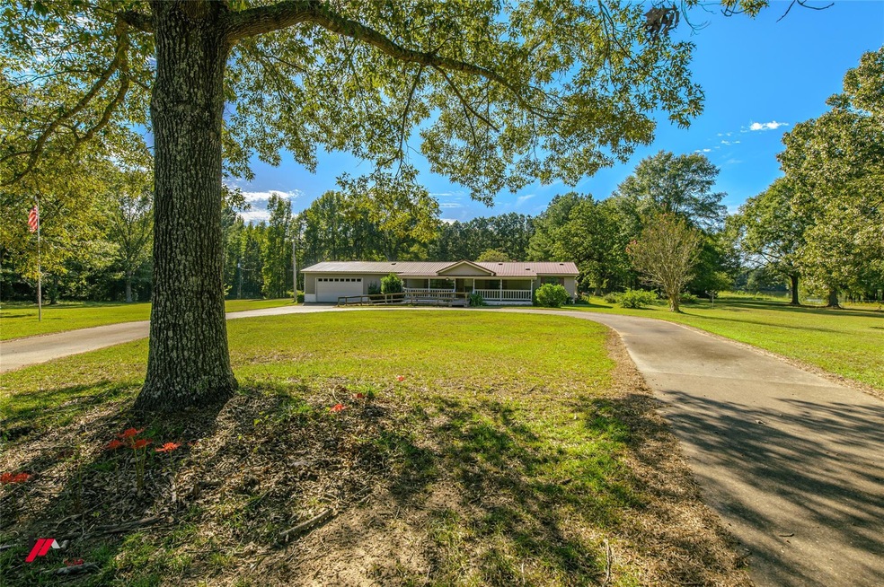 Ranch-style home featuring a front yard and a gara