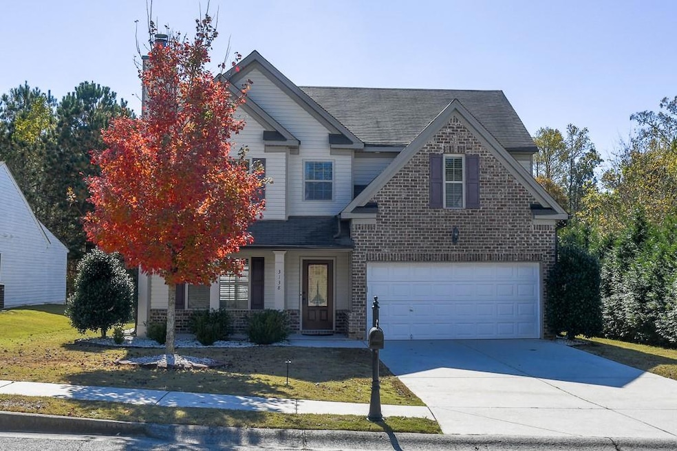 Traditional home featuring covered porch, brick siding, roof with shingles, and driveway