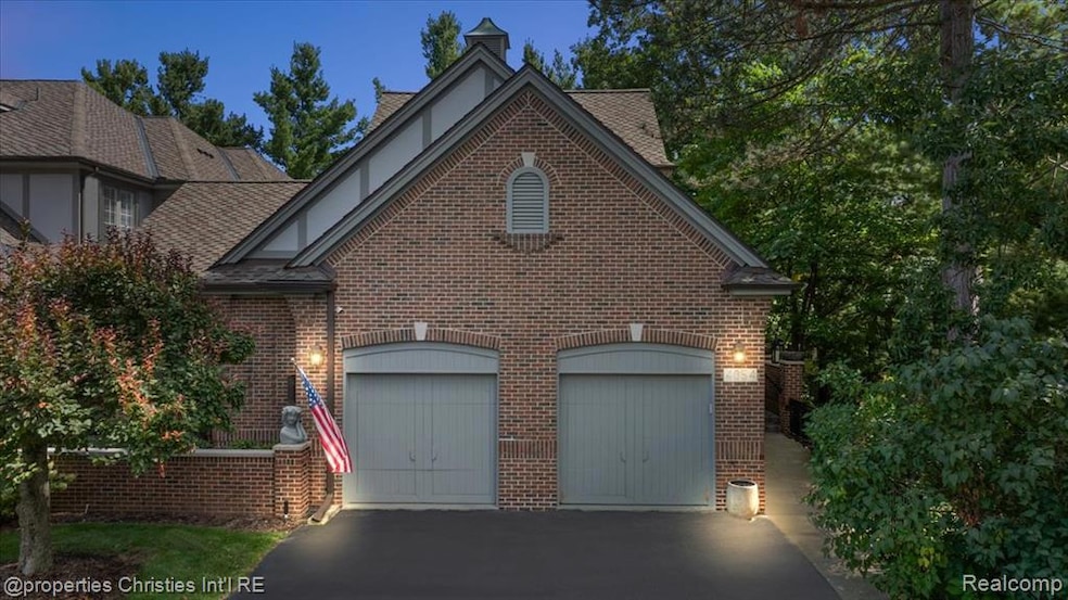 View of front facade with driveway, brick siding, and an attached garage
