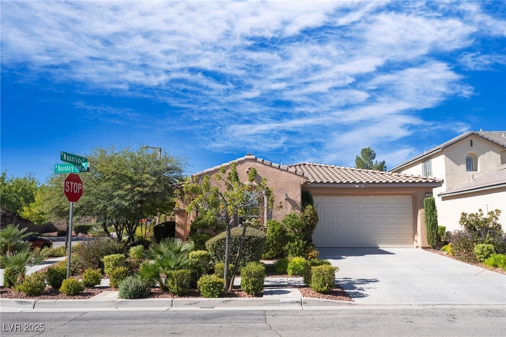 Mediterranean / spanish home with a tiled roof, driveway, stucco siding, and an attached garage