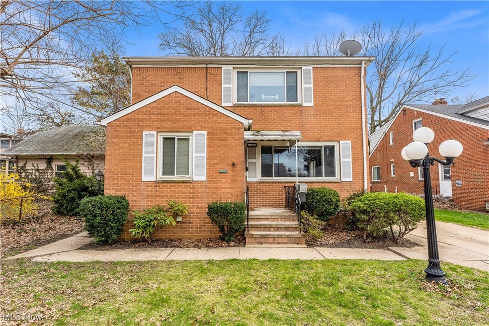 Traditional home featuring brick siding, a front lawn, and fence
