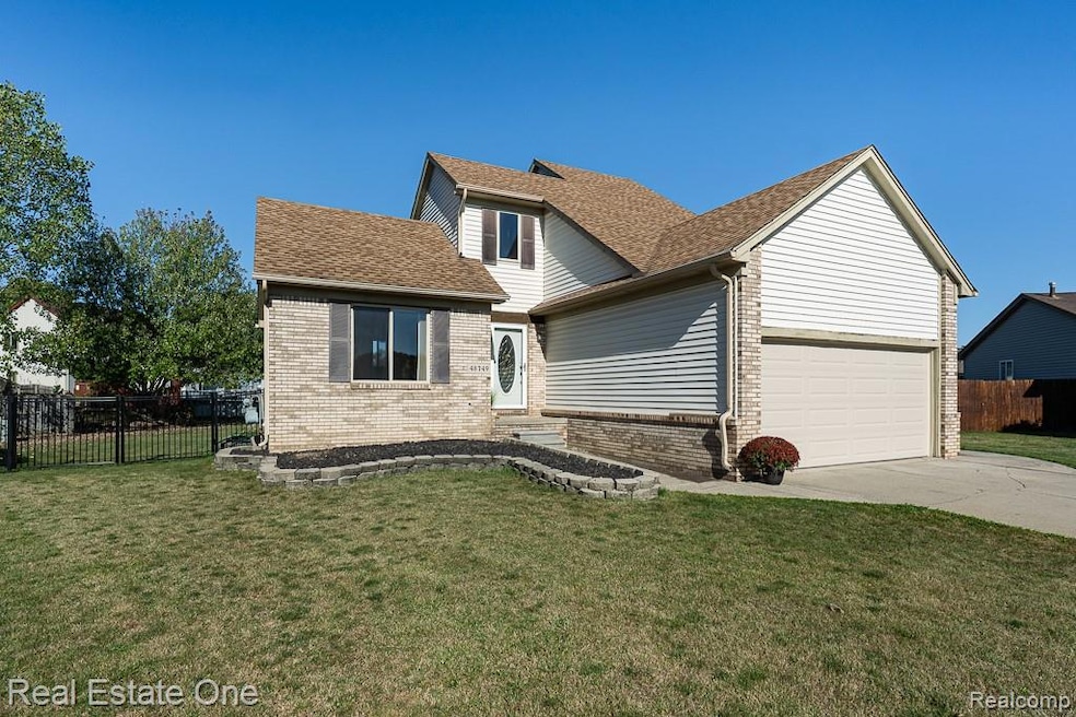 Traditional-style site condo featuring roof with shingles, a garage, brick siding, and driveway