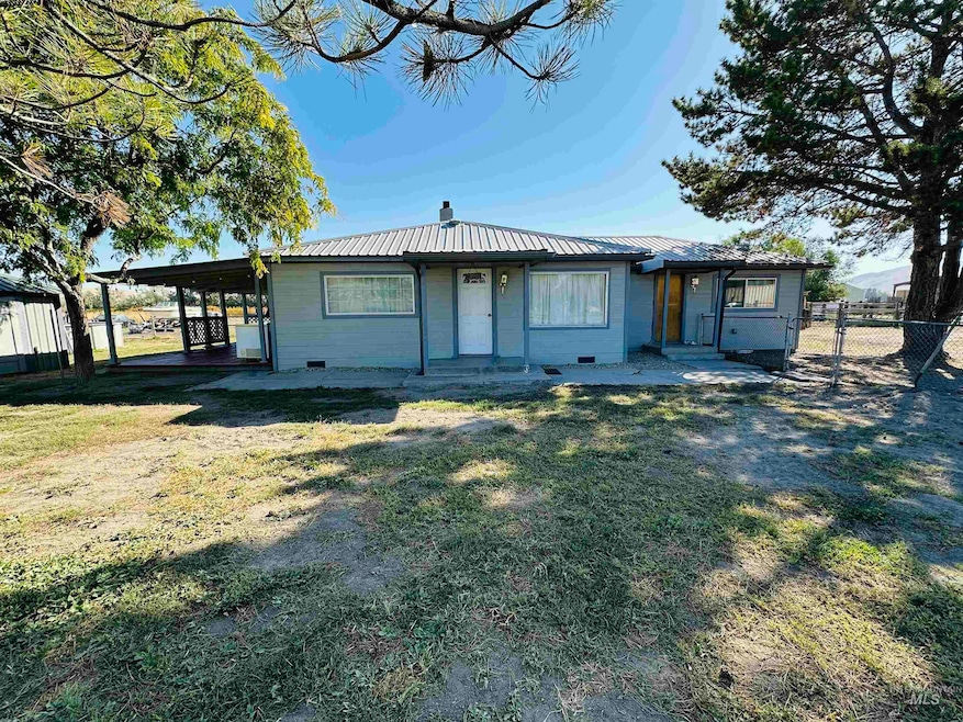 View of front facade featuring a metal roof, a patio, a chimney, and an attached carport