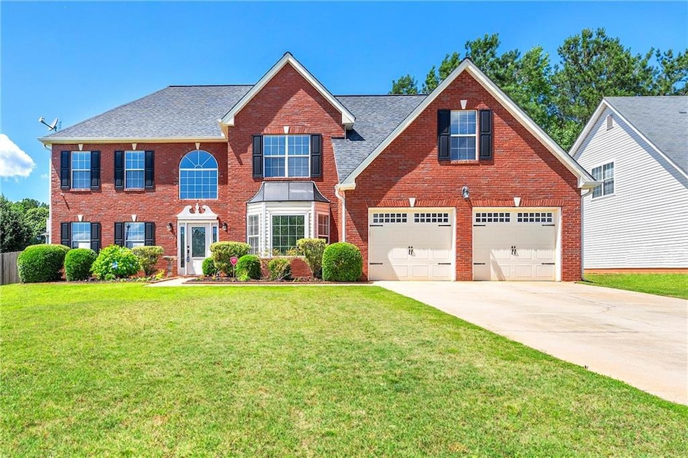 View of front of house featuring driveway, brick siding, an attached garage, a front lawn, and a shingled roof