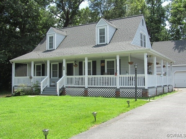 View of front of home with a porch, a front lawn,
