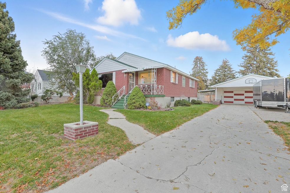 Bungalow with an outdoor structure, a front yard, and driveway