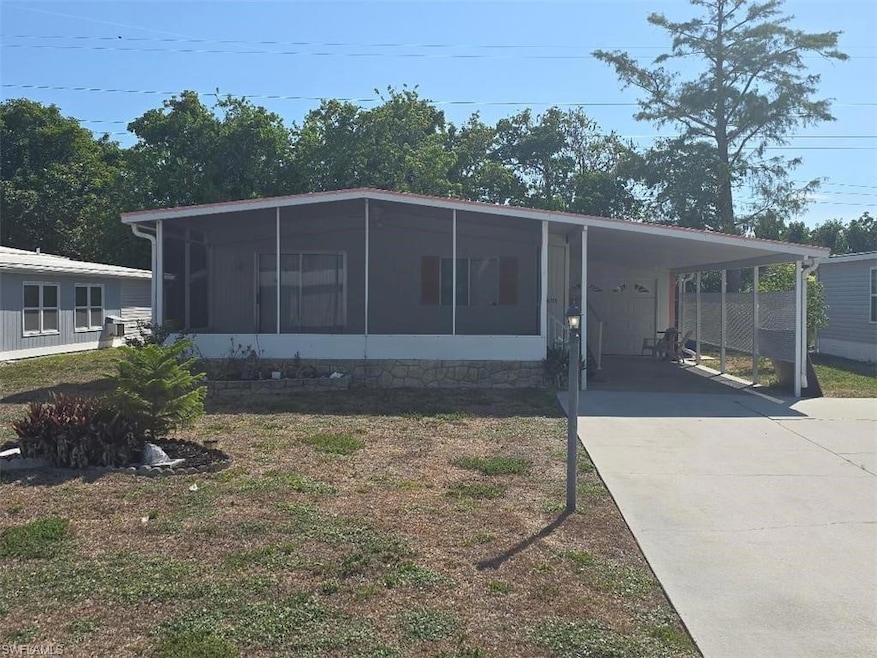 View of front facade with a sunroom, concrete driveway, and a carport