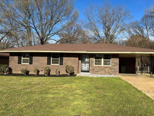 Single story home featuring brick siding, an attac