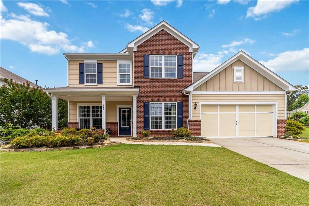 View of front facade with brick siding, concrete driveway, a front lawn, and an attached garage