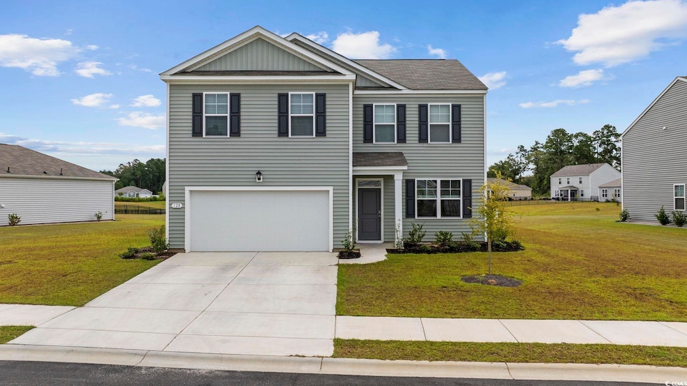 View of front of home with a garage and a front la