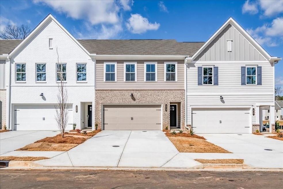 MODEL REPRESENTATIVE- View of front of house with board and batten siding, driveway, an attached garage, and brick siding