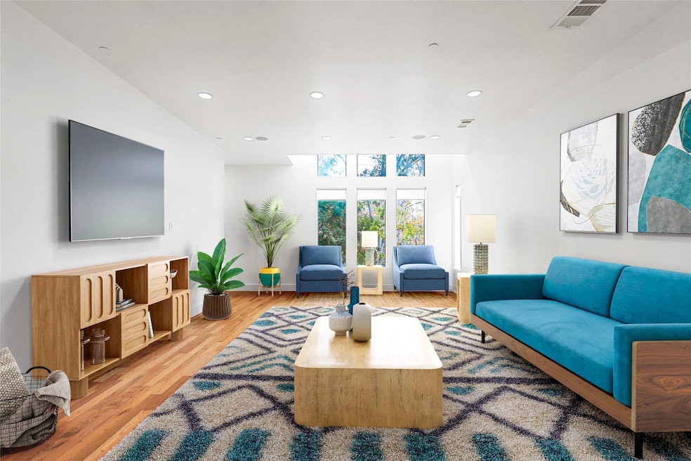 Living area with light wood-style floors and recessed lighting