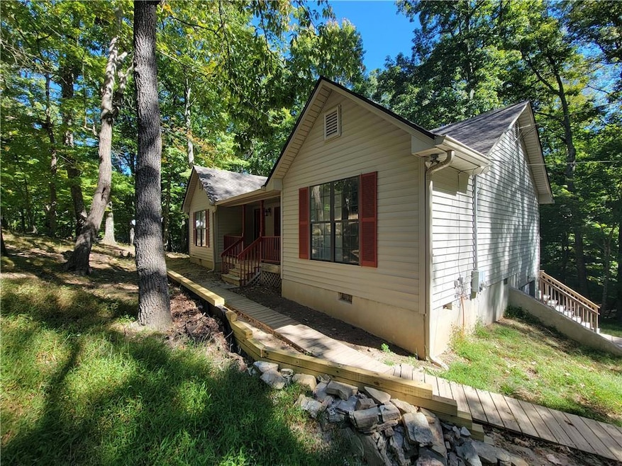 View of property exterior with crawl space, a wooden deck, and a shingled roof