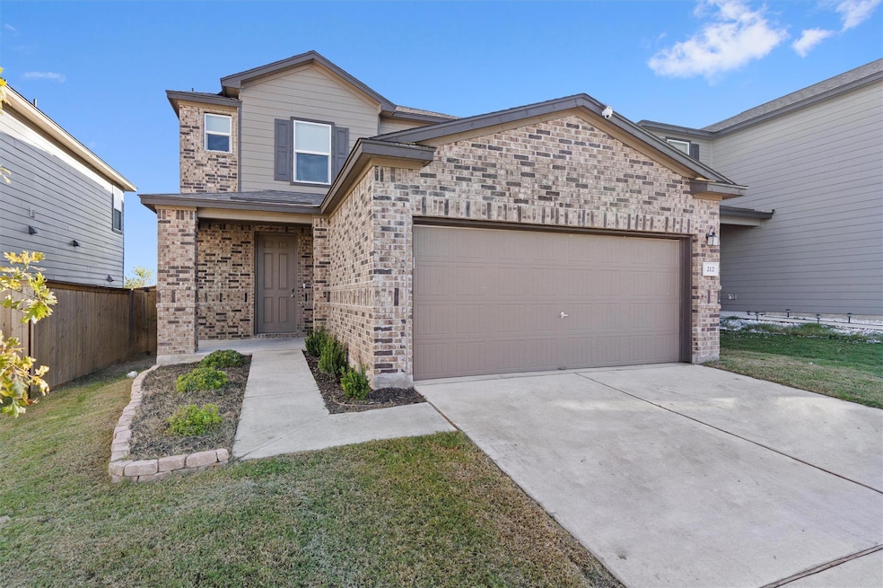 View of front of home with brick siding, concrete driveway, and an attached garage
