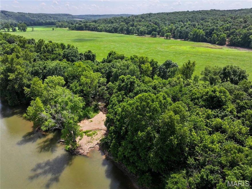 View of rural area with a large body of water and a heavily wooded area