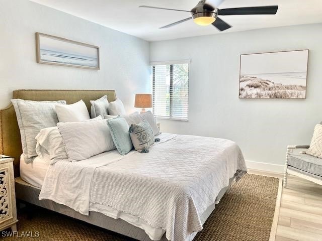 Bedroom with ceiling fan, baseboards, and wood finished floors