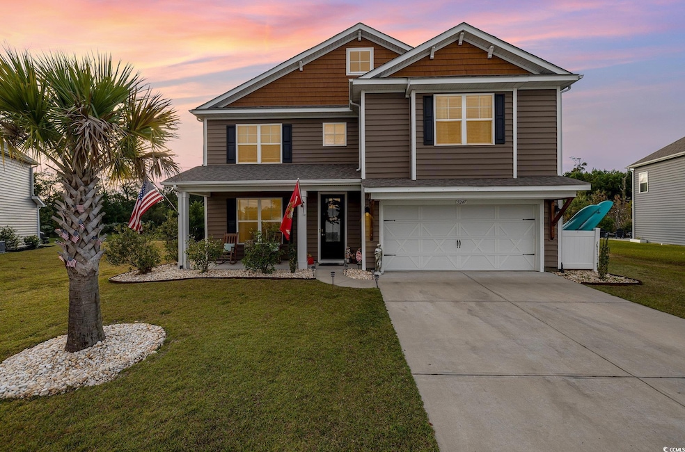 View of front facade featuring covered porch, a ga