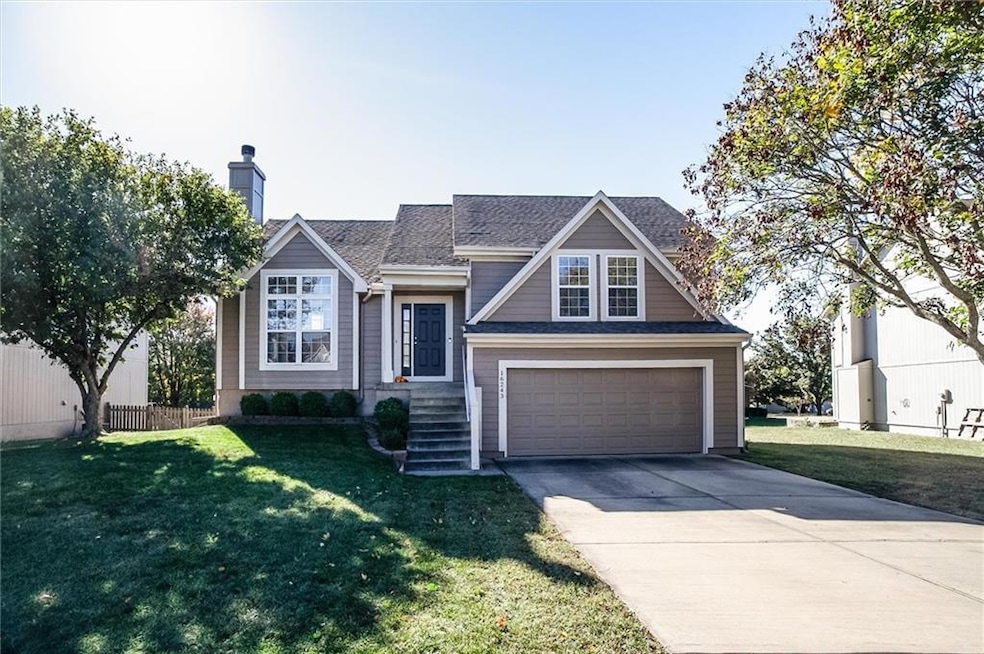 View of front of property featuring concrete driveway, an attached garage, and a shingled roof