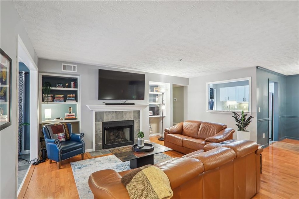 Living room featuring a fireplace, built in featur