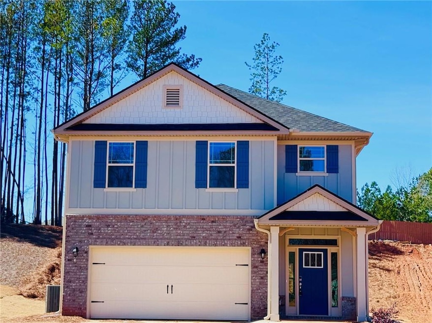 View of front facade featuring an attached garage, board and batten siding, brick siding, concrete driveway, and a shingled roof