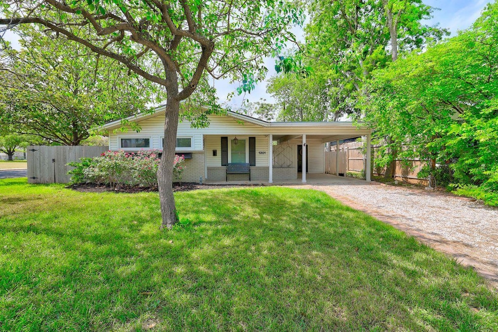 Ranch-style home with dirt driveway, fence, an at