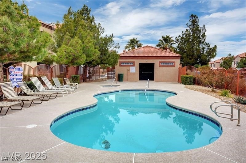 Pool with a patio, fence, and a gate