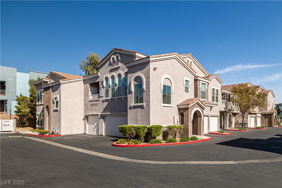 View of property with stucco siding, a garage, a r