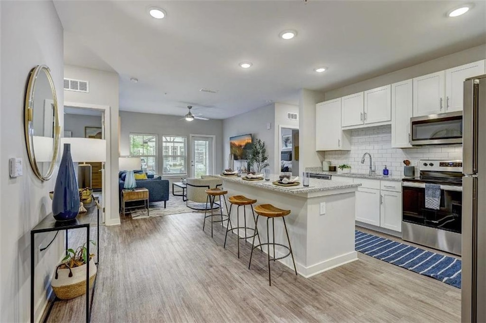 Kitchen with light wood-style flooring, a sink, ap