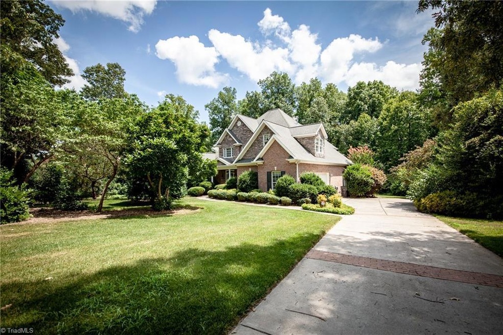 Picturesque setting on nearly 1.5 wooded acres, this beautiful home is tucked between the trees and nestled back off the street