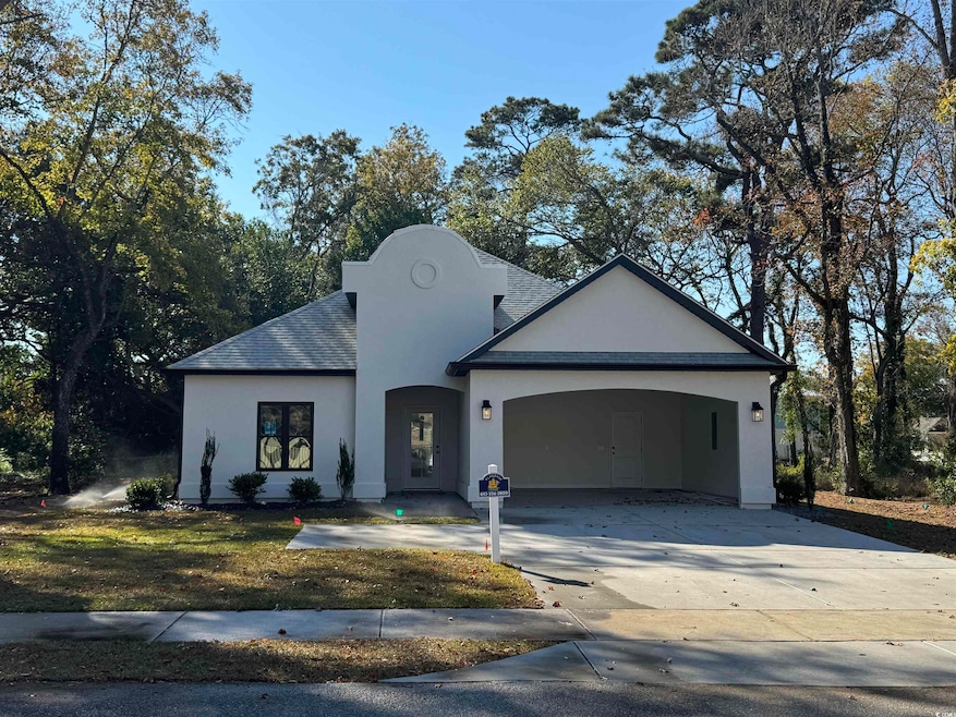 View of front of home with stucco siding, concrete driveway, and a garage