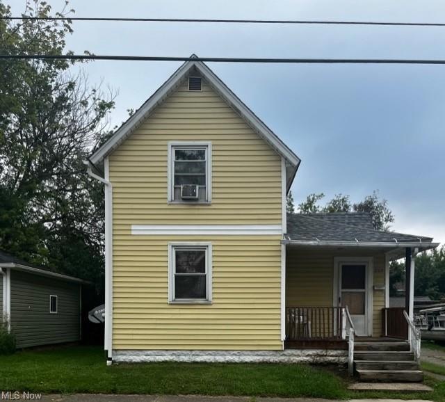 Rear view of house featuring a yard