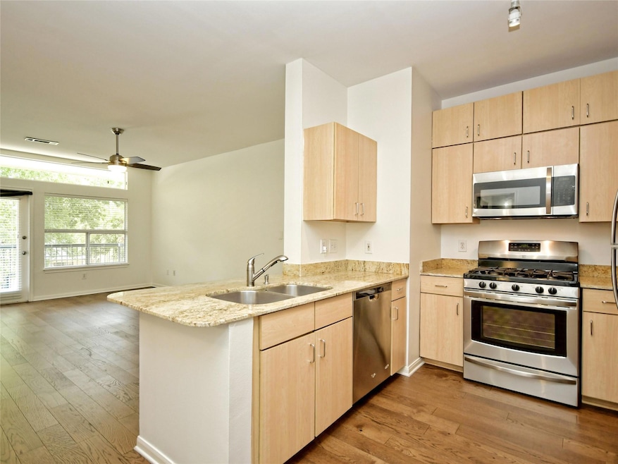 Kitchen featuring light brown cabinets, light sto