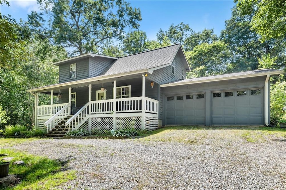 View of front facade with driveway, a garage, and a porch