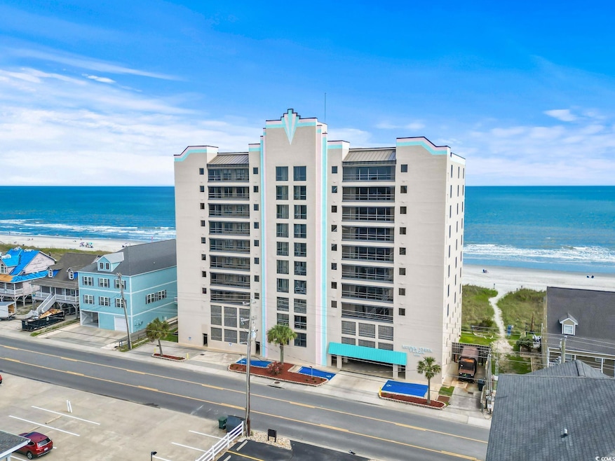 View of apartment building / complex with view of water and beach