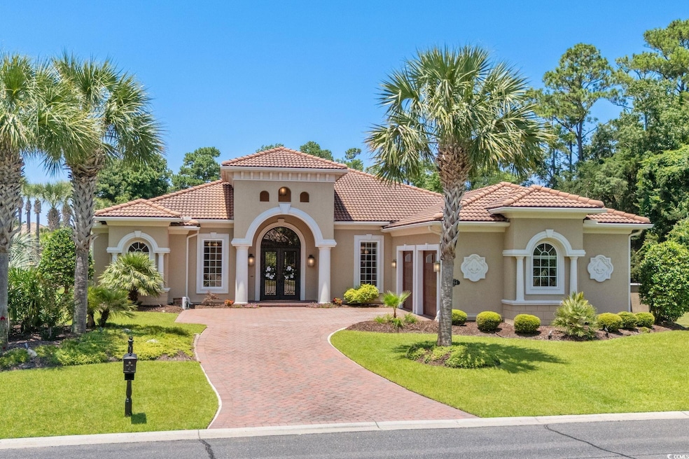 View of front of property featuring french doors, a tiled roof, decorative driveway, and stucco siding