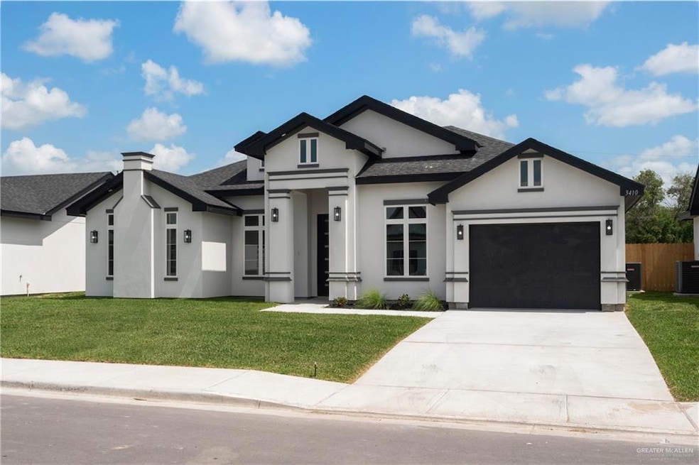 View of front of home with stucco siding, roof with shingles, a garage, driveway, and a front lawn