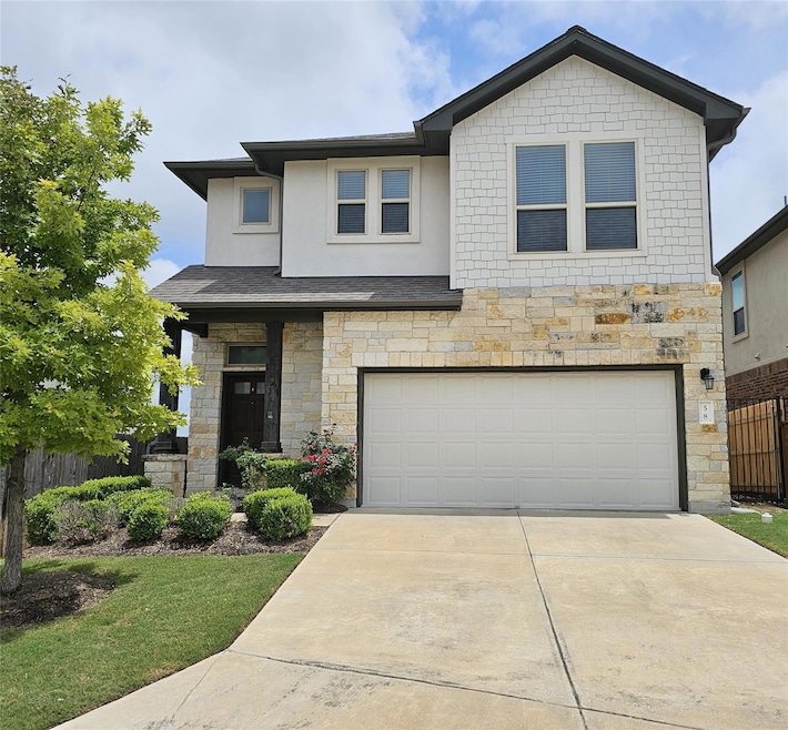 View of front of property with stone siding, a ga