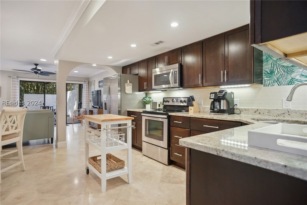 Kitchen featuring light stone countertops, dark br