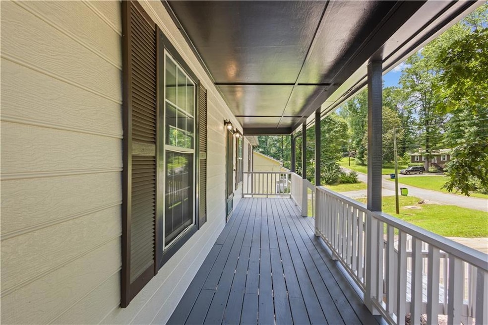 View of front facade with covered porch, an attached garage, stairs, concrete driveway, and a metal roof