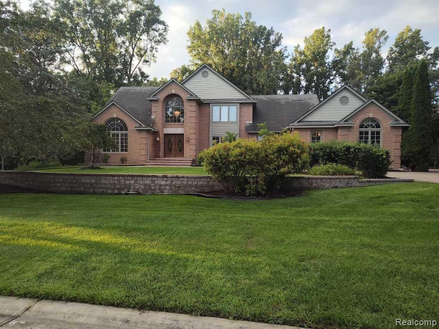 View of front of house with a front yard and brick siding