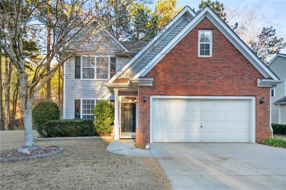 Traditional-style house featuring brick siding and concrete driveway