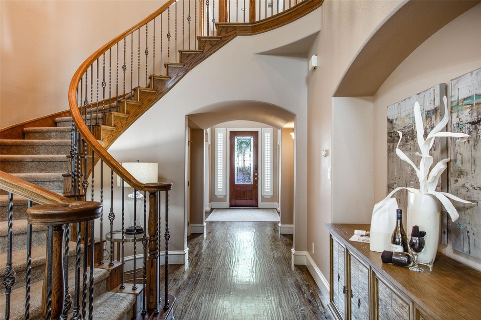 Foyer entrance featuring dark hand-scraped hardwood floors and tall 2-story ceilings